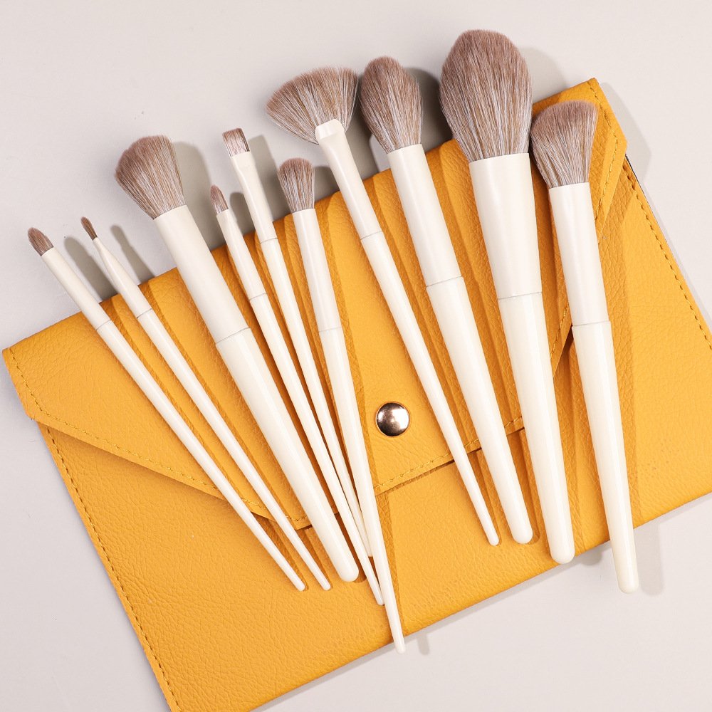 10 different off-white makeup brushes in a yellow wallet-style genuine leather packaging
