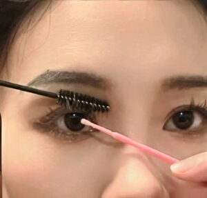 A young woman cleaning her eyelash extensions following Shewincosmetic's guidelines