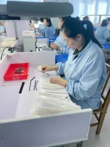 Shewincosmetic workers in uniforms performing quality inspection on newly produced eyelash extensions in the lab